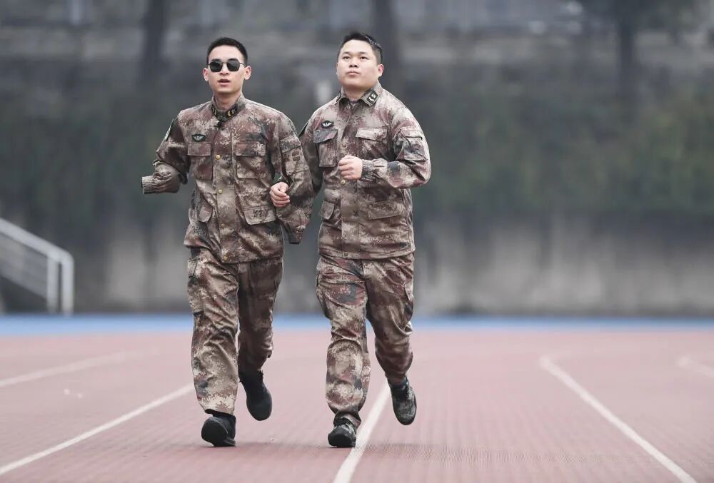 2020年1月2日,“排雷英雄战士”杜富国(左)和战友在陆军军医大学操场上跑步。新华社记者 王全超 摄